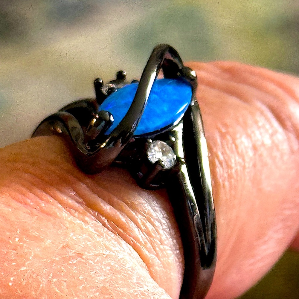A beautiful black ring with a deep blue opal style